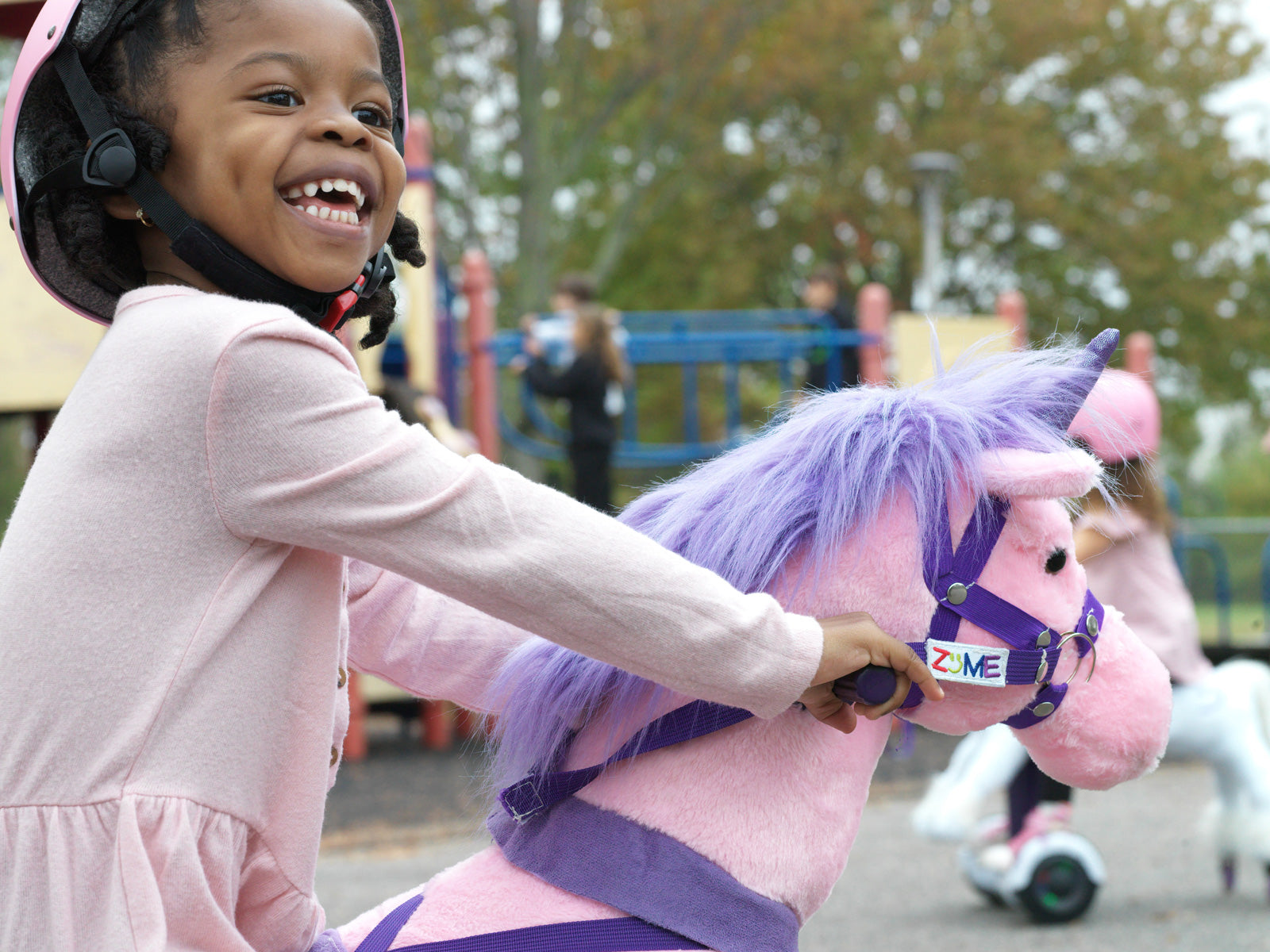 girl in pink helmet riding a pink power pony