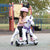 girl in pink shirt and helmet riding a white power pony