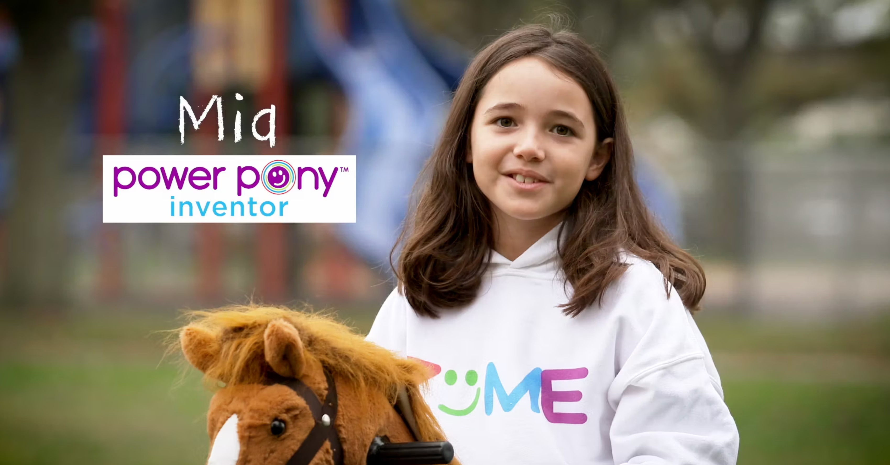 Mia, Power Pony inventor, holding a pony toy outdoors with Power Pony logo.