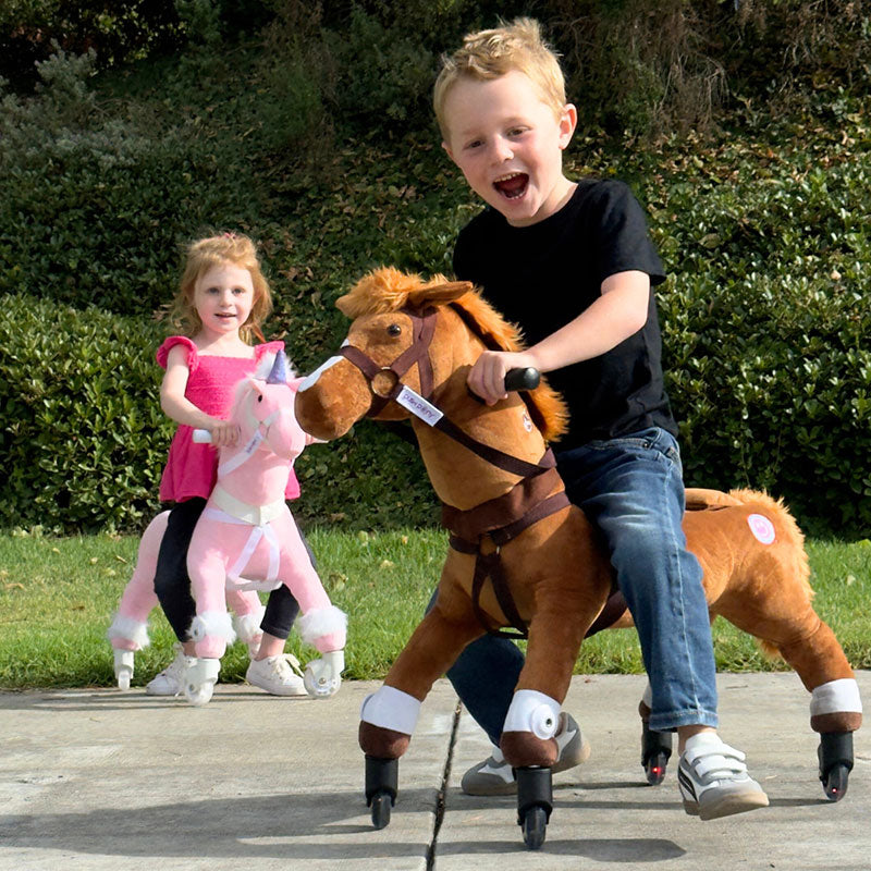 Excited boy riding a brown Power Pony with a girl on a pink Power Pony in the background.